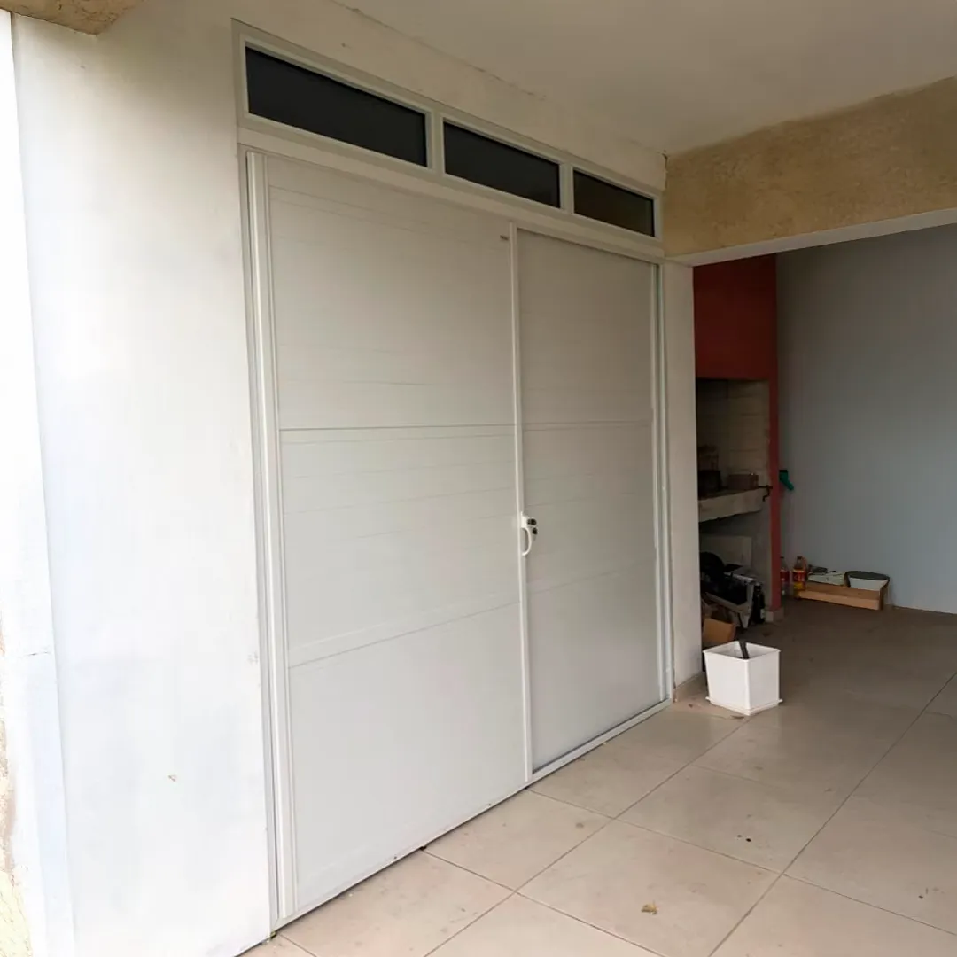 Robusto portón en aluminio blanco con ventanales fijos 